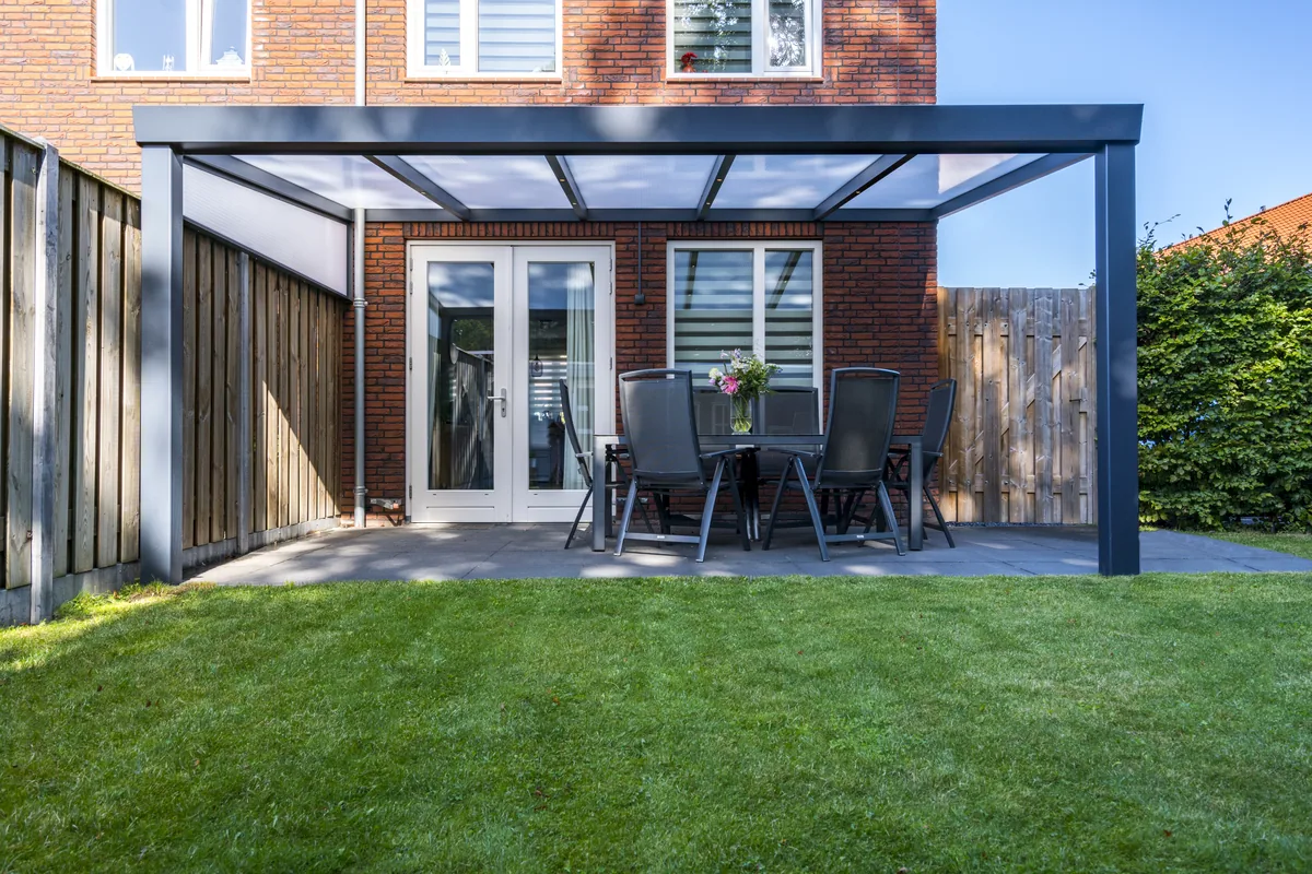 Giallo veranda with a clear glass roof over a garden patio